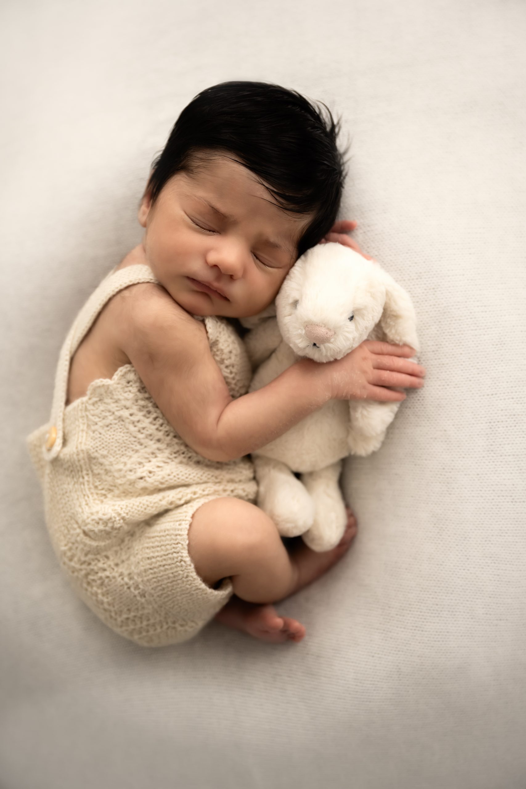 Cute newborn baby cuddled up with a beautiful bunny. Timeless, perfect photograph taken by ISJ in Romford Essex